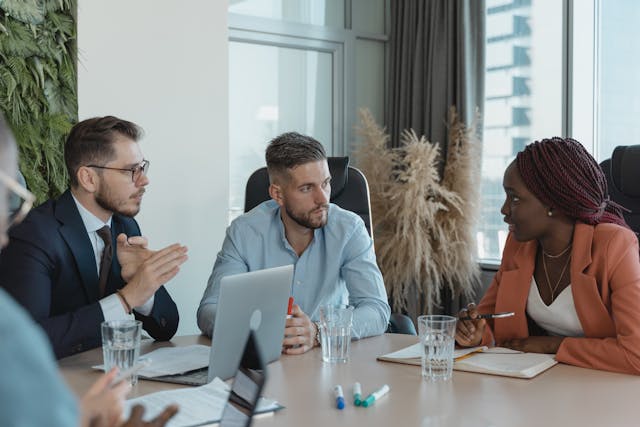 a-group-of-professionals-engaged-in-a-discussion-around-a-conference-table-in-a-modern-office-setting