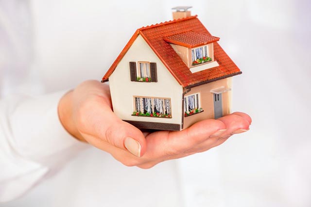 a-miniature-house-with-a-red-roof-being-held-in-a-persons-hand a-miniature-house-with-a-red-roof-being-held-in-a-persons-hand